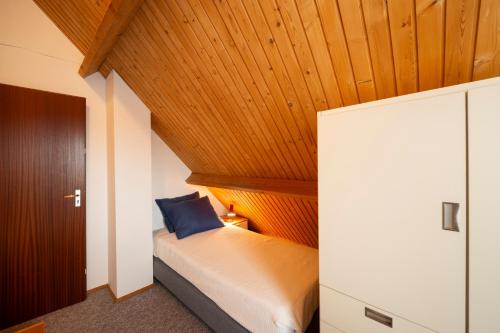 a bedroom with a bed with a wooden ceiling at De Duiker in Wolphaartsdijk