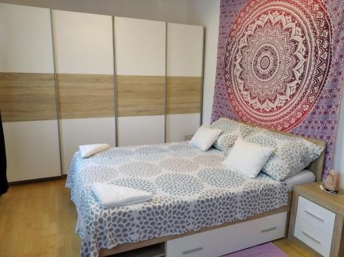 a bedroom with a bed and a wall mural at Balatoni Mandala Vendégház in Balatonszemes