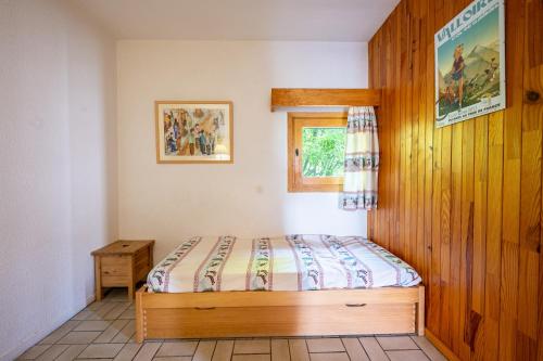 ein kleines Schlafzimmer mit einem Bett und einem Fenster in der Unterkunft Les Arolles n°G54 in Valloire