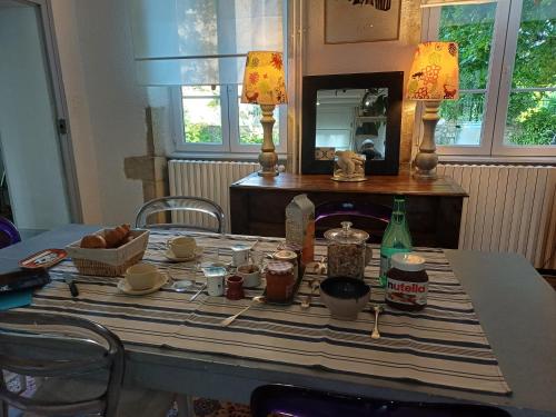 a table with a table cloth with food on it at Chic & charme au Presbytère in Saint-Genès-du-Retz