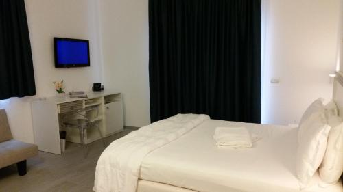 a hotel room with a bed and a television at Hotel Miramare in Marina di Ragusa