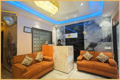 una hall con due divani marroni e un uomo in piedi al bancone di Amritsar Hotel Singh International - Providing AC & Non AC Rooms With Free Wi-fi - Lift & Free Parking Facility - Excellent Room Service - A Premium Hotel In Amritsar ad Amritsar