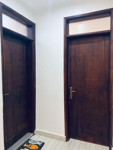 two wooden doors in a room with a rug at Entire Furnished Apartment Unit in Kira in Kira
