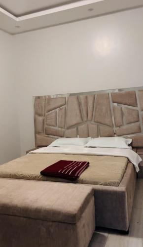 a large bed with a large headboard in a room at Entire Furnished Apartment Unit in Kira in Kira
