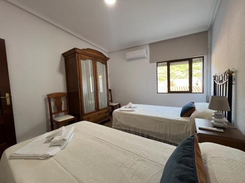 a hotel room with two beds and a window at MIRADOR DE CABEZUELA "Precioso apartamento con terraza en el Valle del Jerte" in Cabezuela del Valle