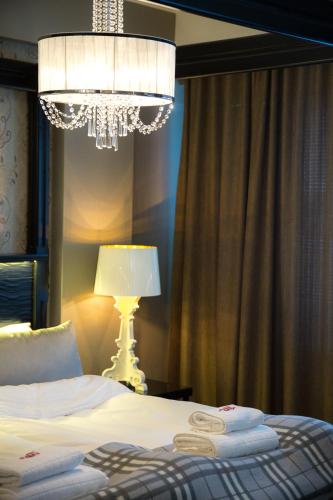 a bedroom with a bed with a lamp and a chandelier at Hotelli Olof in Tornio