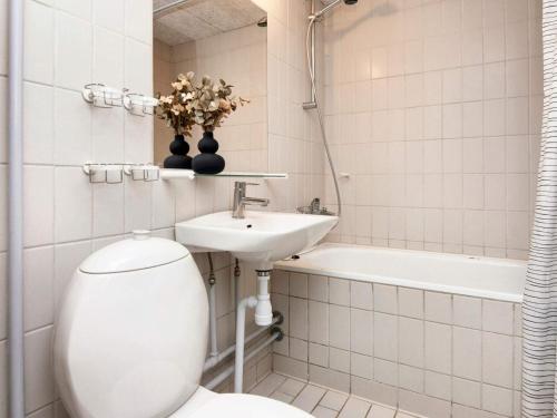 a bathroom with a toilet and a sink and a bath tub at Apartment in Holiday park- free waterpark in Ulfborg