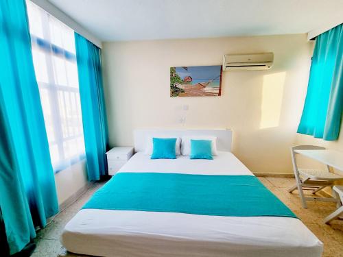 a bedroom with a large bed with blue curtains at 610 Agia Napa in Ayia Napa