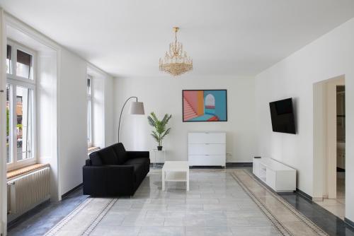 a living room with a black couch and a tv at Hotel Resslirytti in Basel