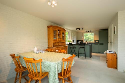 a kitchen and dining room with a table and chairs at De Duiker in Wolphaartsdijk