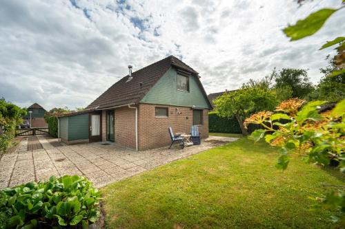 a house with a green roof and a patio at De Duiker in Wolphaartsdijk