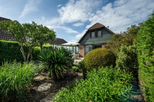 a house with a garden and an umbrella at De Duiker in Wolphaartsdijk