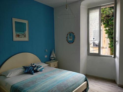 a bedroom with a bed with blue walls and a window at Cà del Giambo in Gargnano