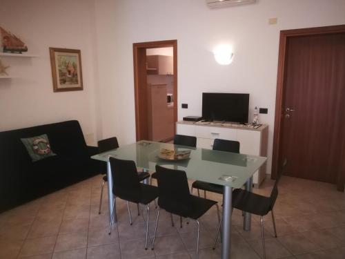 a dining room with a green table and chairs at La Casa dei Pescatori in Caorle
