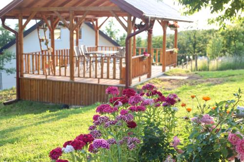 a gazebo with a table and some flowers at House Trebević ReStart in Petruše