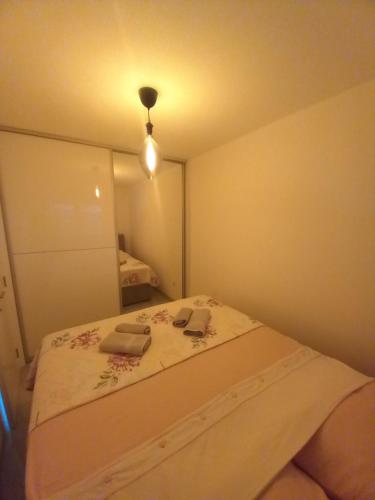 a small bedroom with a bed with two books on it at Apartman Jana 2 in Doboj