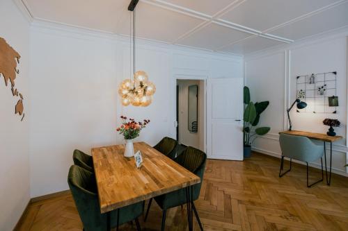 a dining room with a wooden table and green chairs at Central Boutique Apartment - Garden with Riveraccess in Thun