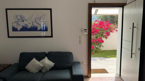 a living room with a couch and a door to a patio at Amazing villa with a magic view to the Aegean in Dhaskalión