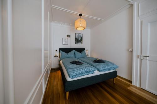 a bedroom with a bed with a blue comforter at Central Boutique Apartment - Garden with Riveraccess in Thun