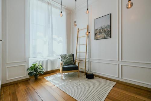 a living room with a chair and a ladder at Central Boutique Apartment - Garden with Riveraccess in Thun