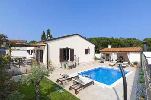 ein Hinterhof mit einem Swimmingpool und einem Haus in der Unterkunft Villa Ridollin in Pula