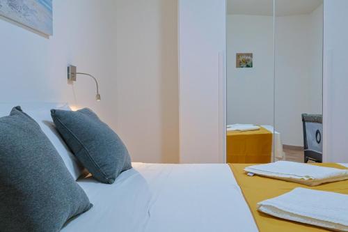 a bedroom with a white bed with pillows and a table at Villa Lella - Pantheon in Ardea