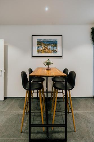 a table and chairs in a room with a painting at Central Boutique Apartment - Garden with Riveraccess in Thun