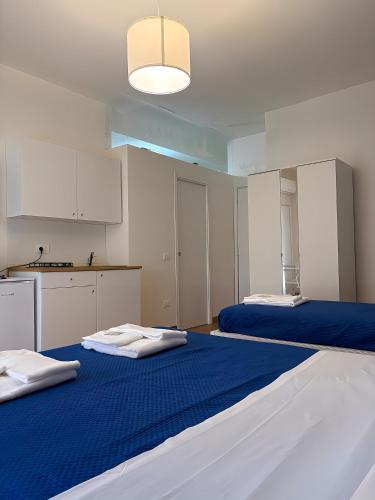 two beds in a room with blue and white at Art Room In Pompei in Scafati