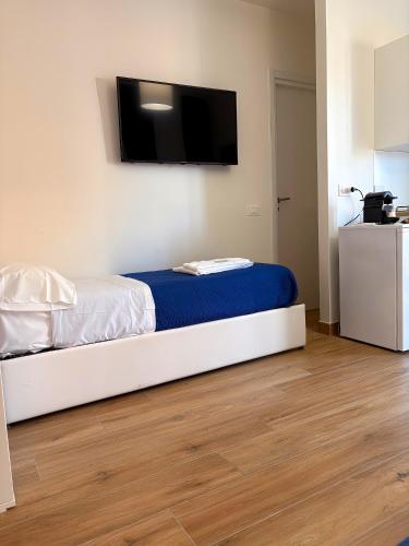 a bedroom with a bed with a flat screen tv on the wall at Art Room In Pompei in Scafati