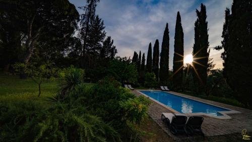 a swimming pool in a yard with chairs and trees at Cefalicchio B&B in Canosa di Puglia