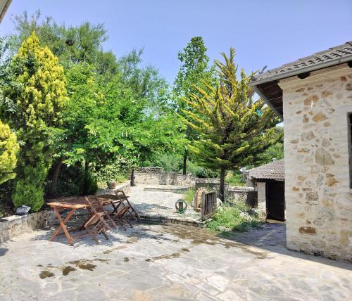 a wooden picnic table in a yard with trees at Yono's Traditional House in Ano Ravenia