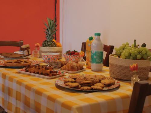 a table with a yellow and white table cloth with food on it at Le Dame Country House, Marche in Montegranaro