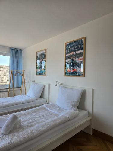 two beds in a room with a window at APARTMENT PD23 ALTE FEUERWACHE I Ganze Wohnung I 5 Einzelbetten I 3 Zimmer I 3min CityHospital I 50m Supermarkt I Küche I SmartTV in Ibbenbüren