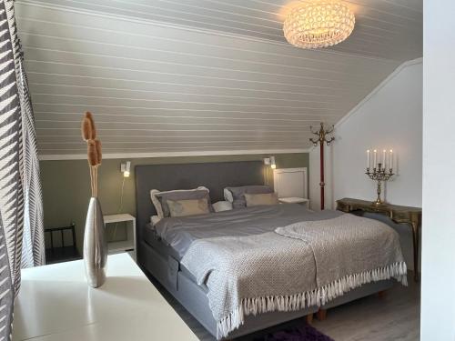 a bedroom with a bed and a chandelier at Villa med panoramautsikt, stor uteplass og 100 m fra badestrand in Bergen