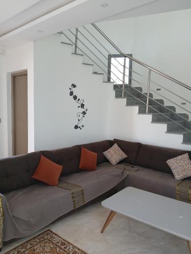 a living room with a couch and a staircase at Villa Olivier rond point du rendez-vous, Midoun in Djerba