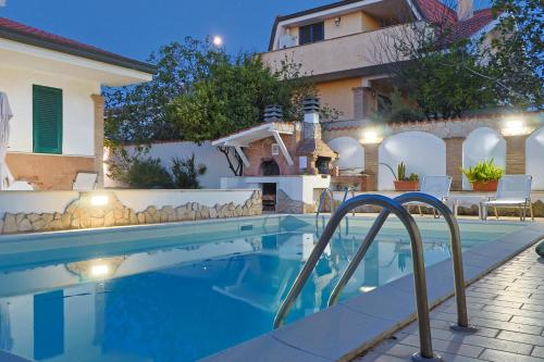 a swimming pool in front of a house at Villa Lella - Pantheon in Ardea