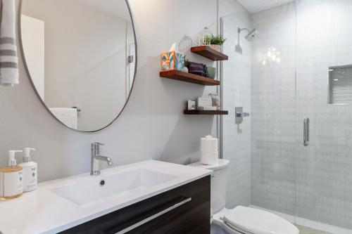 a bathroom with a sink and a mirror and a toilet at LuxuryDenver Studio w Hot Tub 2 Mi to Downtown in Denver