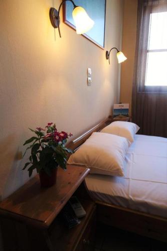 a bedroom with a bed and a table with a potted plant at Syros Studios in Ermoupoli