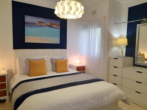 a bedroom with a bed and a chandelier at Seafront apartment Terrace, lounger & Panoramic ocean views in Mellieħa