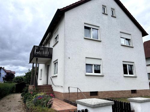 a white house with windows and a balcony at Zentral und ruhig EG in Hirschaid