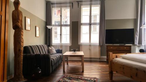 a living room with a couch and a tv at Kunsthaus mit Frühstück im Hotel Theophano in Quedlinburg