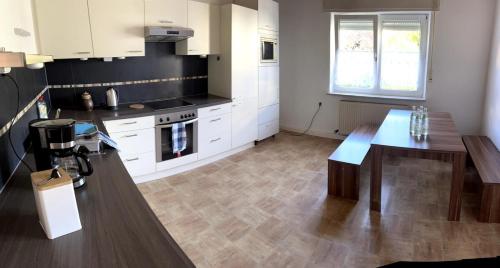 a kitchen with white cabinets and a wooden counter top at Zentral und ruhig EG in Hirschaid