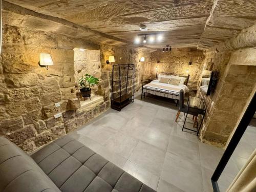 a room with a bed in a stone wall at Kappella boutique in Malta in Żurrieq