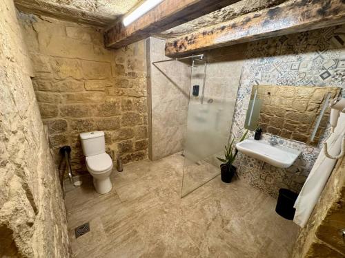 a stone bathroom with a toilet and a sink at Kappella boutique in Malta in Żurrieq