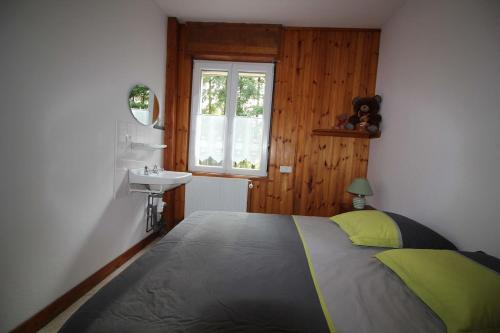 une chambre avec un lit, un lavabo et une fenêtre dans l'établissement Gîte Les Jonquilles IV, à Le Bonhomme