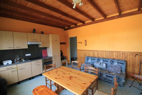 - une cuisine avec une table et des chaises en bois dans la chambre dans l'établissement Gîte Les Jonquilles IV, à Le Bonhomme