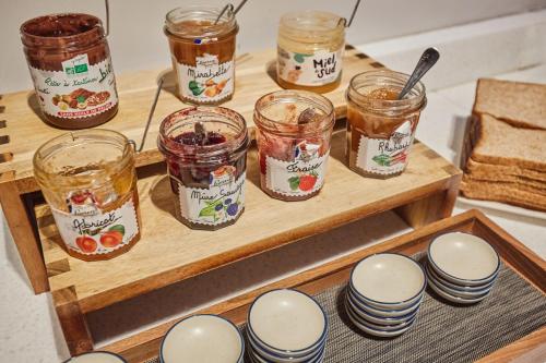 a table with jars of jam and bowls and plates at Appart Hotel Odalys City Aix en Provence L'Atrium in Aix-en-Provence