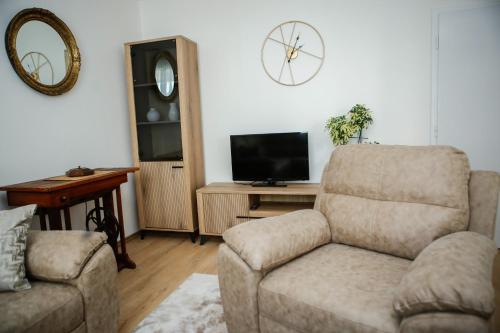 a living room with a couch and a chair and a television at Adi apartment in town centar in Konjic