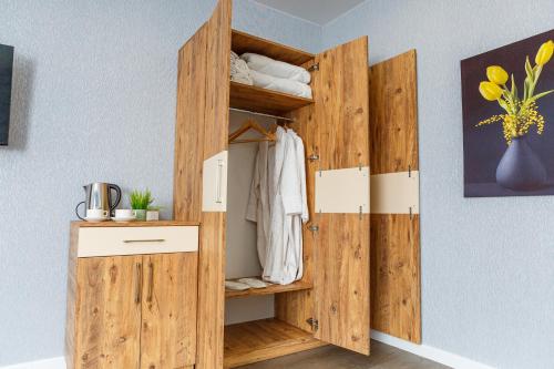 a wooden closet with open doors in a room at Golden Pheasant in Tbilisi City
