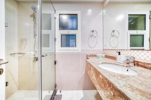 a bathroom with a sink and a shower at Stella Stays Barsha Heights in Dubai